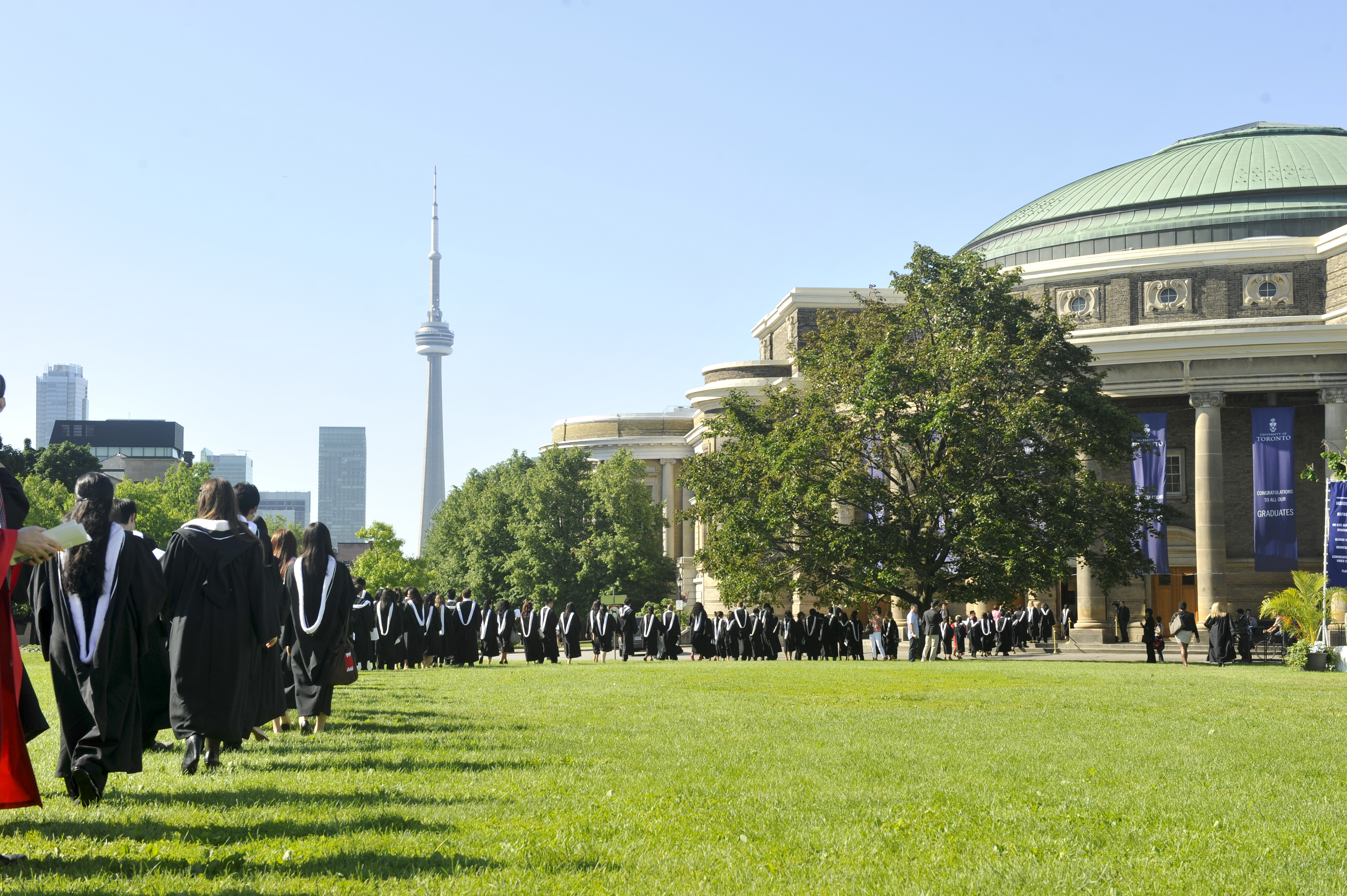 This is a picture of UofT's convocation hall, with the CN tower in the background, and the King's Circle Field in view